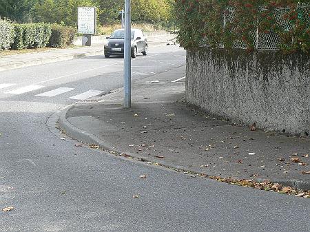 P1090058.JPG - Le trottoir abaissé devrait permettre d'atteindre la piste cyclable. Mais aucune signalisation ne le précise et il reste un dénivelé. Sans parler de l'obstacle que constitue le luminaire.